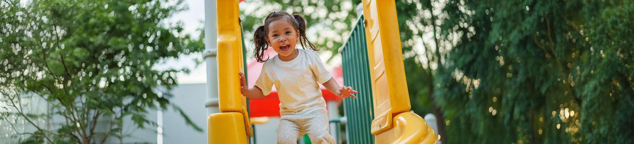 Young girl in kindergarten playing on the playground
